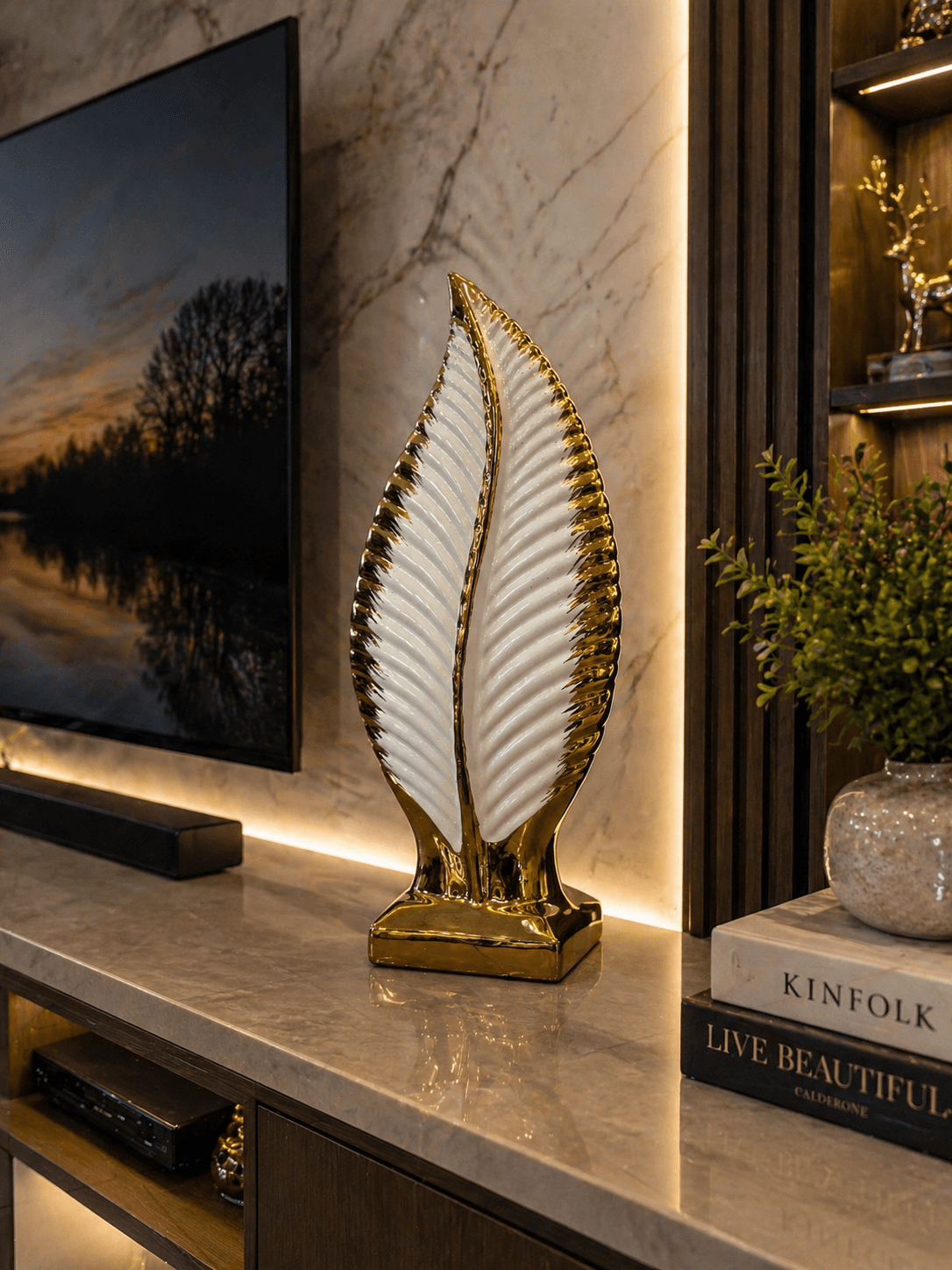 Modern white and gold leaf ceramic showpiece displayed on a living room TV console next to decorative books preview 2
