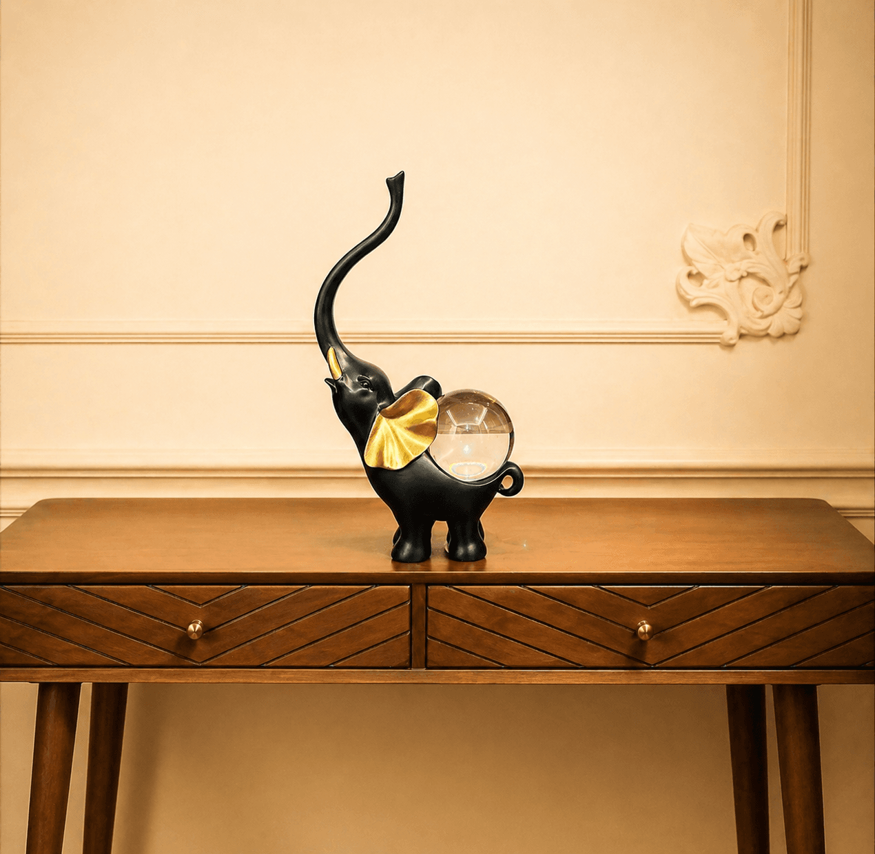 Pair of black elephant statues with golden ears and clear crystal balls on their backs, displayed on a wooden entryway console table preview 2