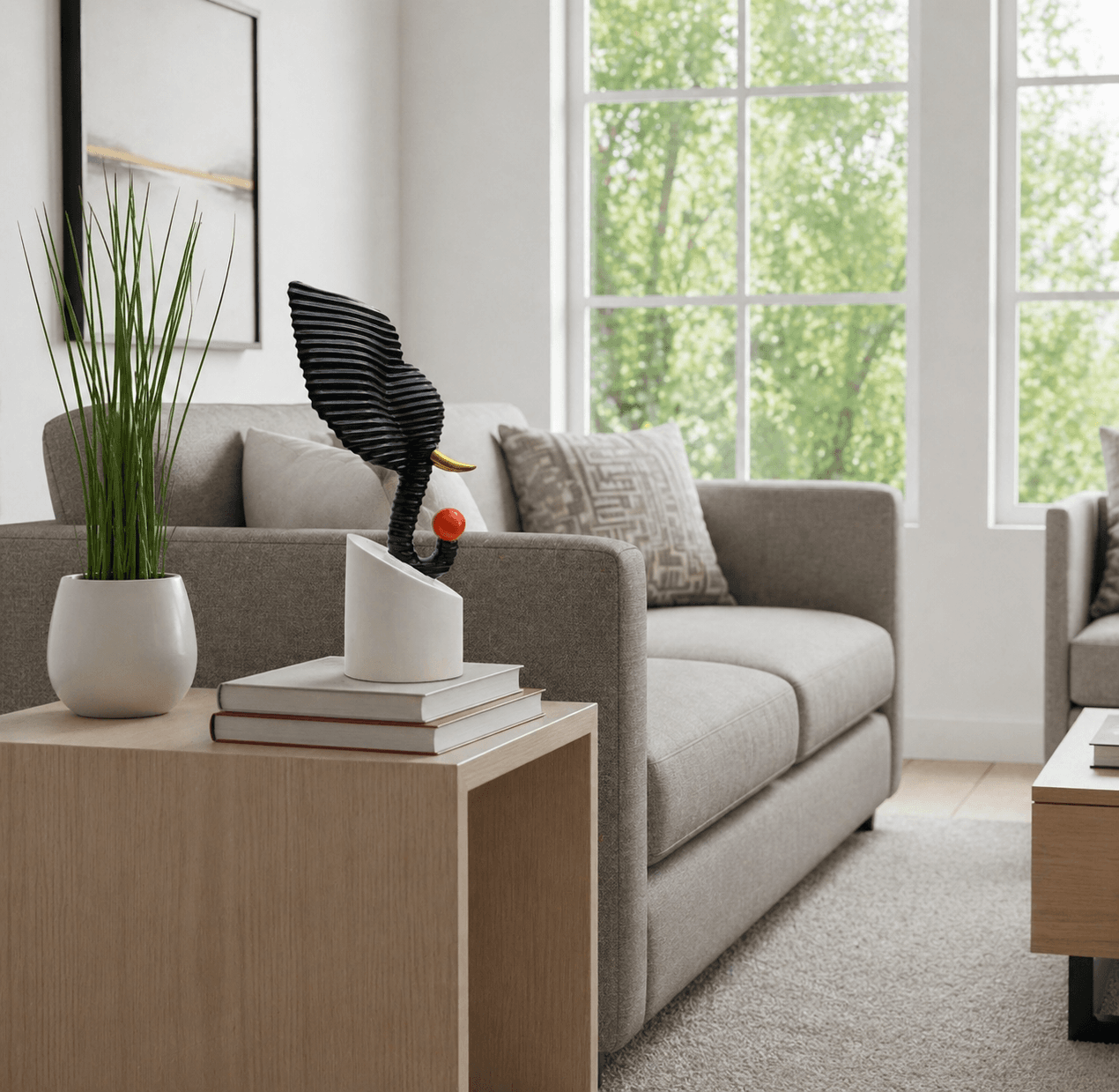 Abstract black textured elephant head sculpture holding a red ball, displayed on a modern living room side table over decorative books preview 2
